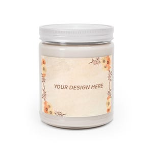 Puede incluir: Una vela de color crema en un tarro de cristal con tapa blanca. La etiqueta presenta el texto "YOUR DESIGN HERE" y est&aacute; decorada con elementos florales en tonos naranja, amarillo y marr&oacute;n. La vela es un art&iacute;culo de decoraci&oacute;n del hogar.