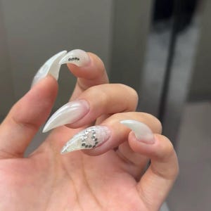 Puede incluir: Un juego de tres tazas de cerámica con acabado mate moteado. Las tazas son de color crema, gris claro y gris oscuro. Cada taza tiene un diseño simple y minimalista.