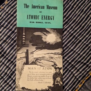 May include: A vintage brochure for The American Museum of Atomic Energy in Oak Ridge, Tennessee. The brochure features a teal and white color scheme with illustrations of atomic energy and the text "Man and the Atom."