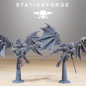 May include: Grey miniature figures with mechanical wings and weaponry, mounted on grey stands. The figures have detailed armour and are posed in action. The text "STATIONFORGE" and a skull logo are at the top.