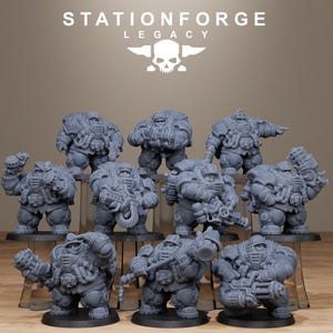Könnte beinhalten: Eine Sammlung grauer Miniaturfiguren von schwer gepanzerten Charakteren, jede mit einzigartigen Waffen und Ausrüstung. Die Figuren sind auf einer mehrstufigen Präsentation angeordnet, mit dem Text "STATIONFORGE LEGACY" und einem Totenkopf-Logo oben.