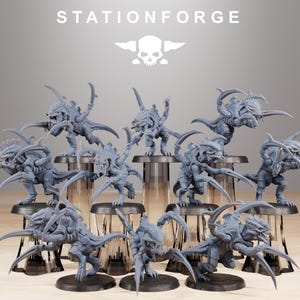 Pode incluir: Uma coleção de miniaturas cinzentas de criaturas insectóides com garras e dentes afiados. As miniaturas estão sobre bases pretas e dispostas em suportes cilíndricos transparentes. A palavra "STATIONFORGE" está impressa no topo.