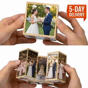 May include: A wooden photo cube featuring wedding photographs. The cube, held in hands, shows images of a bride and groom, and a wedding party. The cube is designed to be rotated to reveal different images.