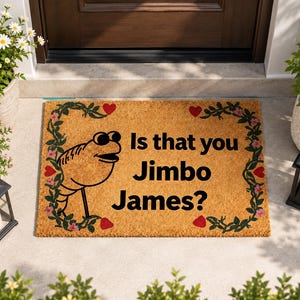 May include: A rectangular tan coir doormat featuring a black line-art illustration of a shrimp wearing sunglasses on the left side. The text "Is that you Jimbo James?" is printed in black. A green vine border with small red hearts surrounds it.