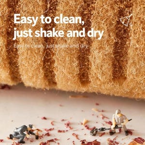 May include: Close-up of a textured, tan-colored cleaning sponge with the text "Easy to clean, just shake and dry." Miniature figures are depicted cleaning up debris. The sponge appears to be made of natural fibers.