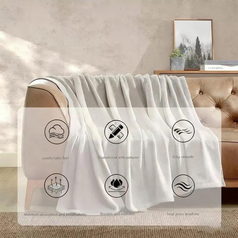 Puede incluir: Una manta blanca y gris sobre un sof&aacute; marr&oacute;n. La manta tiene una textura suave y sedosa. La imagen incluye texto que dice "comfortable feel", "Customized with pictures", "Silky smooth", "Moisture absorption and breathability", "Durable and washable" y "heat press machine".