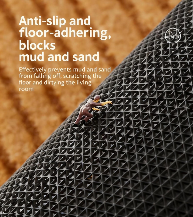 May include: A close-up of a black, anti-slip mat with a geometric pattern. The mat is designed to block mud and sand, with text that reads "Anti-slip and floor-adhering, blocks mud and sand". A small figurine is climbing the mat.