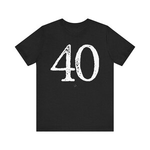 May include: Black t-shirt with the number 40 in a distressed white font. The number is centered on the shirt, taking up a significant portion of the front. The shirt has short sleeves and a crew neck.