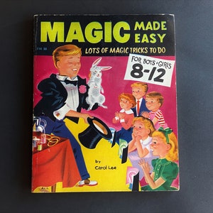 May include: A vintage book titled Magic Made Easy with the subtitle Lots of Magic Tricks to Do. The cover features an illustration of a magician pulling a white rabbit from a black top hat for a group of children. It is marked for boys and girls 8-12.