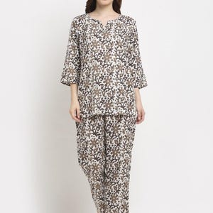 May include: A two-piece pajama set featuring a floral pattern in shades of brown and white. The top has a v-neck and three-quarter sleeves. The matching pants are loose-fitting.