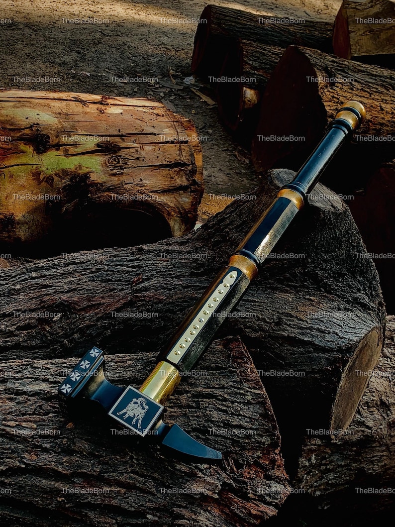May include: A black and gold battle hammer with a detailed design. The hammer features a square head with a cross design and a rectangular emblem with a horse and rider. The handle is black with gold accents.