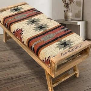 May include: Wooden bench with a patterned cushion in beige, red, black, and grey. The bench has a light brown wooden frame. The text "Floor Rugs Decor" is visible. The bench is suitable for a hallway or living room.