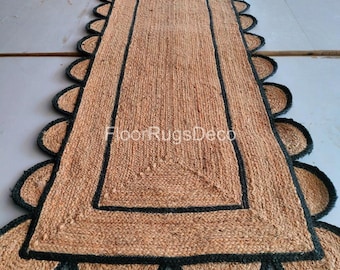 May include: A rectangular jute rug with a scalloped edge and a black border. The rug has a natural tan color and the text "FloorRugsDeco" is visible. The rug is made of woven jute material.