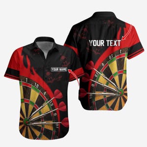 Puede incluir: Camisa de manga corta con diseño de diana, dardos rojos y el texto "YOUR TEXT" y "YOUR NAME". La camisa tiene un fondo negro con detalles en rojo.