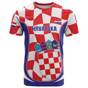 May include: A short-sleeved t-shirt with a Croatian flag design. The shirt features a red and white checkered pattern, the word "HRVATSKA" in blue, and Croatian coat of arms imagery. The sleeves and sides are blue.