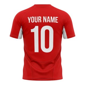 May include: Red athletic jersey with white accents on the sleeves. The back of the jersey features the text "YOUR NAME" above the number "10" in white, centered on the back.