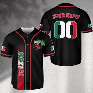 Puede incluir: Camiseta de béisbol negra con detalles rojos y blancos, que muestra la palabra "MEXICO" verticalmente en la parte delantera. La camiseta presenta los colores de la bandera mexicana y un emblema de gallo. La parte trasera tiene el texto "YOUR NAME" y el número "00".