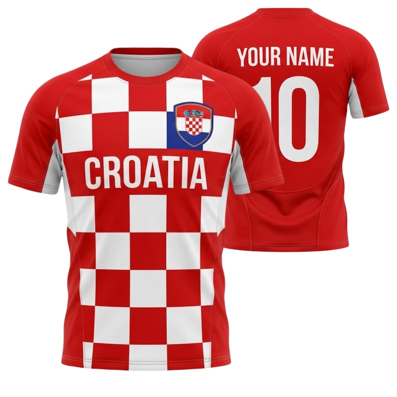 May include: A red and white checkered Croatia soccer jersey with the word "CROATIA" across the chest. The jersey has a Croatian coat of arms on the chest and the number 10 on the back. The back of the jersey also has the text "YOUR NAME".