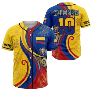 Könnte beinhalten: Ein gelbes, blaues und rotes Baseball-Trikot mit dem Wort "COLOMBIA" und der Nummer "10" auf dem Rücken. Die Vorderseite zeigt die kolumbianische Flagge und florale Designs. Die Ärmel tragen die Aufschriften "NAME" und "YOUR".