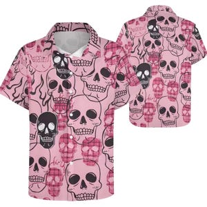 May include: Pink short-sleeved button-down shirt with a repeating skull pattern. The skulls are in black and pink, with some featuring a plaid design. The shirt has a classic collar and a relaxed fit, suitable for casual wear.