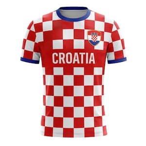 Op de afbeelding: Een rood en wit geblokt Kroati&euml; voetbalshirt met het woord "CROATIA" op de borst gedrukt. Het shirt heeft een blauwe kraag en manchetten, en een Kroatisch wapenschild staat op de rechterborst.