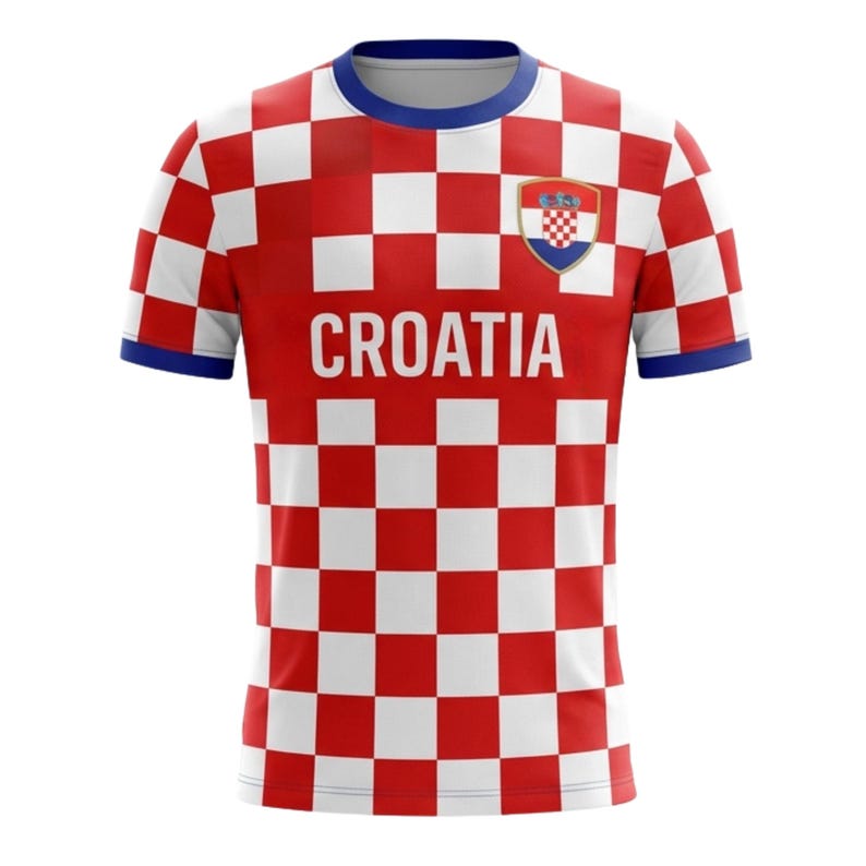 Op de afbeelding: Een rood en wit geblokt Kroati&euml; voetbalshirt met het woord "CROATIA" op de borst gedrukt. Het shirt heeft een blauwe kraag en manchetten, en een Kroatisch wapenschild staat op de rechterborst.