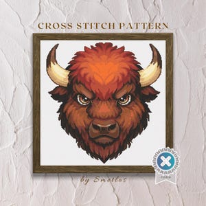Può includere: Schema a punto croce raffigurante una testa di bisonte dettagliata con un'espressione feroce. Il bisonte ha pelo marrone e arancione, grandi corna ed è incorniciato in un bordo di legno. Il testo "CROSS STITCH PATTERN" è in alto.