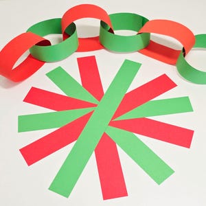 May include: A decorative display of red and green paper chains and strips. The chains are interlinked, while the strips are arranged in a starburst pattern. The colour scheme suggests a festive or celebratory occasion.