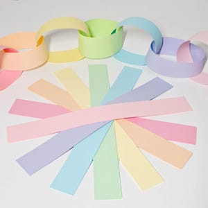 May include: A collection of pastel-coloured paper strips arranged in a sunburst pattern, with several strips looped together to form a decorative paper chain. The colours include soft pink, peach, yellow, light green, blue, and lavender.