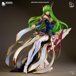 May include: A detailed anime figure of a woman with long green hair, wearing a dark blue and white dress with gold accents. The figure is seated on a decorative base with red and gold elements. The figure has a dynamic pose.