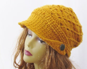 May include: A mustard yellow crocheted beanie with a wide brim and a decorative button.