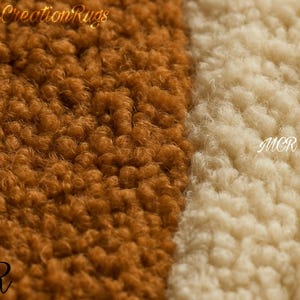 May include: Close-up of a rug with a textured, looped pile. The rug is divided into two sections: one in a warm brown hue and the other in a creamy off-white. The letters "MCR" are visible in the lower corners. The words "Modern Creation Rugs" are at the top.
