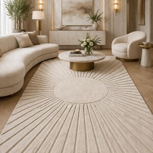 May include: A beige area rug with a sunburst design in a modern living room. The rug's pattern radiates from a central circle. The room features a curved sofa, round coffee table, and neutral color palette.