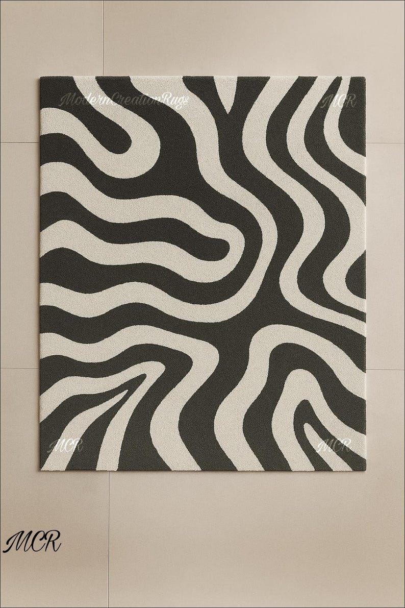 May include: A rectangular rug with a repeating pattern of wavy, cream-colored stripes against a dark gray background. The rug has the text "Modern Creation Rugs" and "MCR" in the corners. This rug is suitable for home decor.
