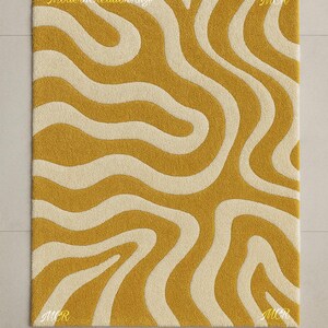 May include: Mustard yellow and cream-colored rectangular rug with a wavy pattern. The rug has a textured surface and the text "Modern Creation Rugs" is visible. The letters "MCR" are in each corner.