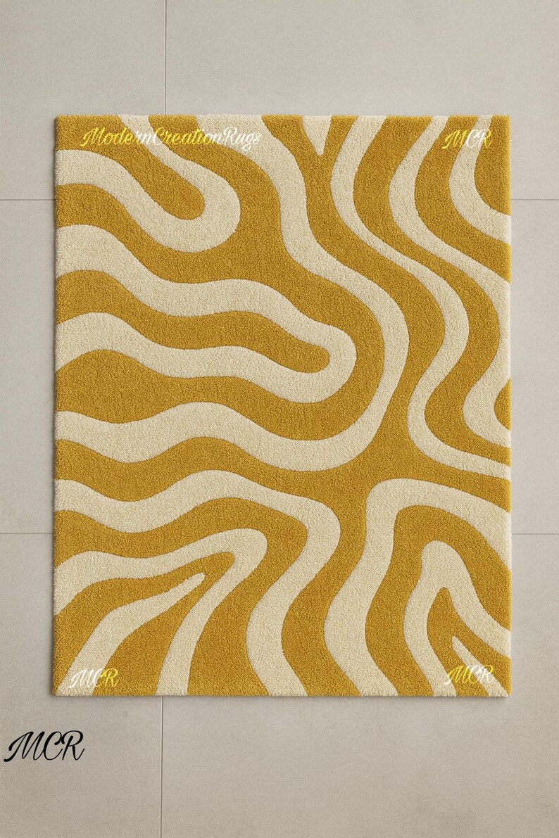 May include: Mustard yellow and cream-colored rectangular rug with a wavy pattern. The rug has a textured surface and the text "Modern Creation Rugs" is visible. The letters "MCR" are in each corner.