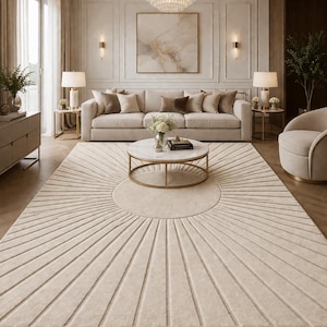 May include: A beige rug with a sunburst design dominates a living room. The rug's pattern radiates from a central circle. A cream-colored sofa with throw pillows, a marble-topped coffee table, and a chandelier complete the elegant interior.