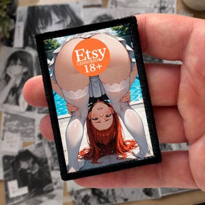 May include: A rectangular embroidered patch featuring an anime-style illustration of a person with red hair bending over in front of a swimming pool. The person wears white thigh-high stockings and a white skirt. An orange circular label reads Etsy CENSORED 18+.