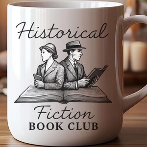 May include: White ceramic mug featuring the text "Historical Fiction Book Club" and a black and white illustration of two figures reading. The mug has a curved handle and sits on a wooden surface.