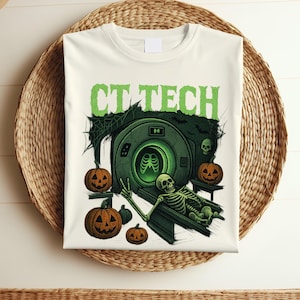 May include: Off-white t-shirt featuring a Halloween-themed design. The graphic includes the text "CT TECH" in green, a skeleton, pumpkins, and a CT scanner. The design is in shades of green, orange, and black.