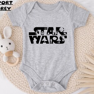 May include: A white ceramic mug with a black handle and the text "But First, Coffee" in a bold, black font. The mug is set against a blurred background, suggesting a cozy setting.