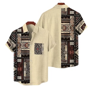 May include: Two short-sleeved button-down shirts. One shirt is displayed front-facing, the other back-facing. The shirts are beige with a geometric pattern in black, brown, and white on the left side and back. The front shirt has a pocket with a geometric design.