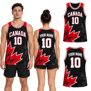 May include: A black basketball jersey featuring a red maple leaf graphic, white trim, and the text CANADA 10 on the front. The back displays the text YOUR NAME and the number 10 in white lettering against a black background with red accents.