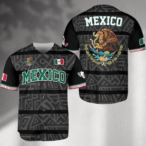 May include: Black baseball jersey with the word "MEXICO" in green and white. The jersey features the Mexican coat of arms and the Mexican flag. The sleeves have a red and green trim with the text "MEXICO FOREVER".