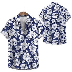 May include: A short-sleeved shirt with a navy blue base, patterned with white hibiscus flowers. The shirt is displayed on a wooden hanger, with a second shirt showing the back of the design. The shirt has a classic collar.
