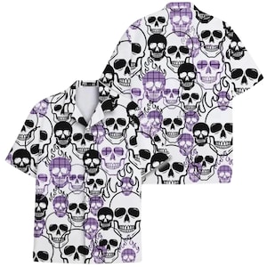 May include: White button-up shirt with a repeating pattern of black and purple skulls. The short-sleeved shirt features a classic collar and a relaxed fit, perfect for casual wear. The skull design includes flames and crosshatch patterns.