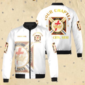 Op de afbeelding: Witte bomberjack met zwarte afwerking, met gouden tekst en een wapenontwerp. De jas toont de woorden "YOUR CHAPTER", "HOC", "VINCES" en "CITY, STATE". Een kruis- en kroonembleem is ook zichtbaar.