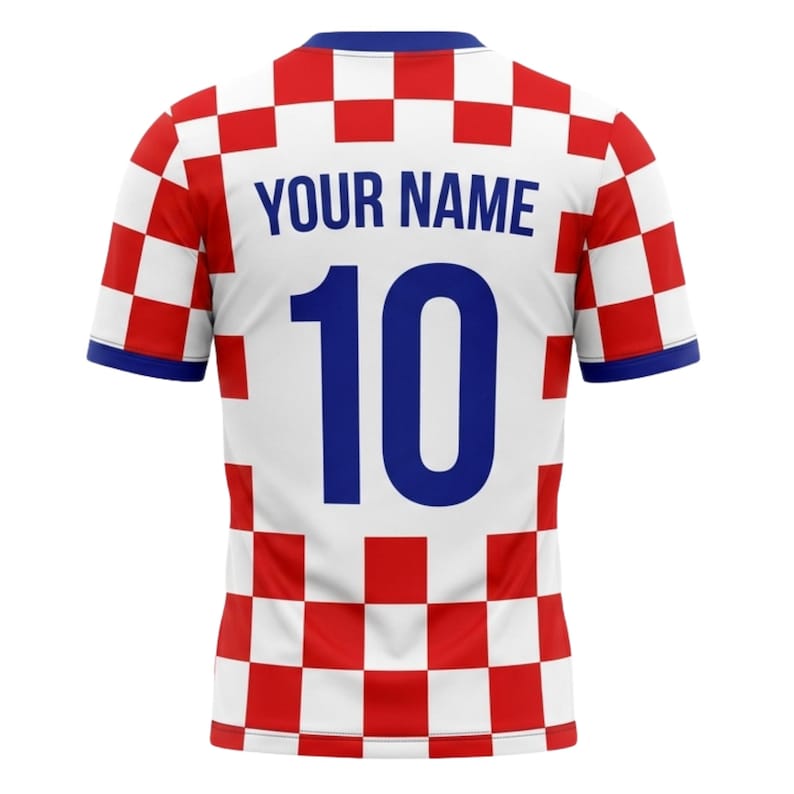 May include: A white and red checkered soccer jersey with blue accents. The jersey features the text "YOUR NAME" above the number "10" in blue. The jersey's sleeves and collar are trimmed in blue.