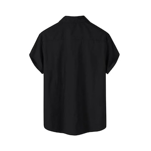 May include: Back view of a black short-sleeved shirt. The shirt has a classic collar and a button-down front. The fabric appears to be a solid, opaque material. The sleeves are short and the overall design is simple and versatile.