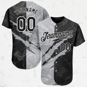 May include: Baseball jersey in a black and grey split design. The jersey features the text "YOURNAME" and "Teamname", along with the number "00" in white. The design includes a pattern of scratch marks and geometric shapes.